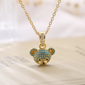Macro shot of 18K gold teddy bear pendant necklace with turquoise beads and micro-zircons