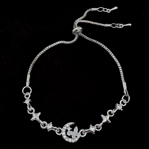 Detailed view of silver adjustable bracelet featuring star, moon, and butterfly charms
