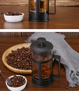 Detail of a heat-resistant glass French press with black frame on a wooden table setup