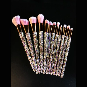 Detailed view of 12-piece glitter makeup brushes with colorful rhinestones on black background