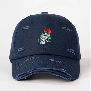 Distressed dark blue baseball cap featuring skull hand holding red rose embroidery