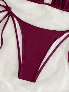 Detailed view of burgundy ribbed bikini bottoms with adjustable side-tie closure details