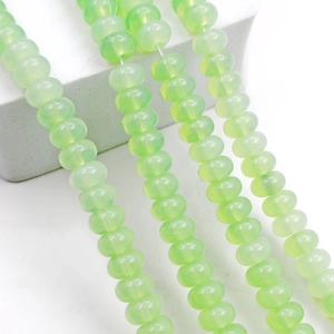 Macro shot of light green translucent abacus glass beads with a jade-like texture