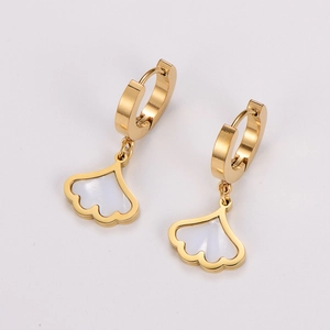 Macro view of golden ginkgo leaf earrings with white enamel finish and shell effect