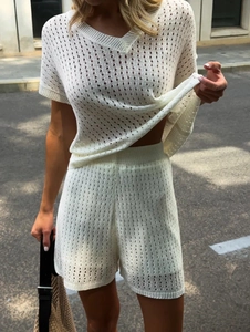 Détail de l'ensemble en tricot crème montrant la texture ajourée sur le haut à col en V