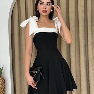 Chic black and white A-line mini dress with oversized bow shoulder straps and square neck