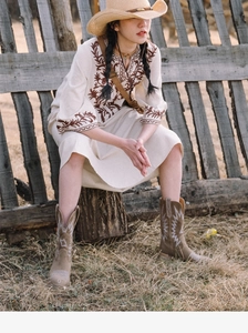 Outdoor fashion styling with beige straw cowboy hat and brown embroidered boots