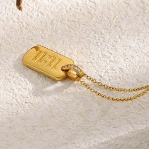 Vue macro du pendentif rectangulaire plaqué or 18K avec relief 11:11 et cristaux sertis