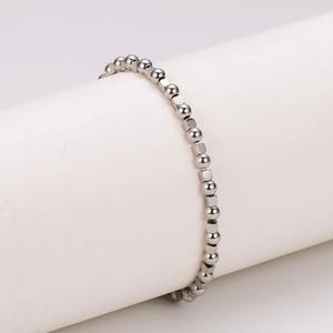 Minimalist stainless steel beaded bracelet featuring industrial silver beads on a pedestal
