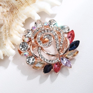 Detailed macro of a gold brooch featuring colorful rhinestones and sparkling gems