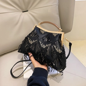 Detail of black sequined evening bag with tassel fringe and golden metal handle