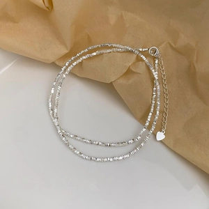 Minimalist 925 silver plated choker with irregular metallic beads and a heart charm