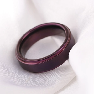 Primer plano de anillo de acero inoxidable cepillado púrpura mate sobre seda blanca