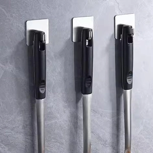 Self-adhesive stainless steel wall hook holding a black cooking spatula on marble tiles
