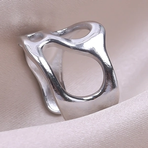 Macro shot of irregular liquid-metal style open ring with polished silver finish