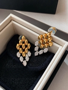Gros plan de boucles d'oreilles losange avec zircons sur un coussin en velours