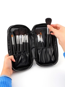 Close-up of black PU leather makeup brush case with elastic slots and assorted brushes