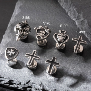Retro stainless steel cross and gothic stud earrings collection on dark stone