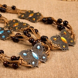 Close-up of woven rope belt with bronze butterfly charms and turquoise beads