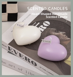 Detail of heart-shaped scented candles in purple and white on decorative books