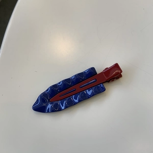 Macro detail of red and blue seamless metal hair clip with a smooth retro texture