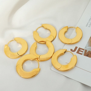 Three pairs of minimalist gold plated geometric hoop earrings on white fabric background