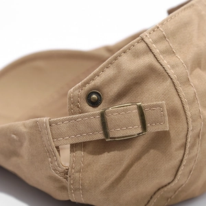 Detail of khaki cotton hat featuring vintage bronze metal buckle and adjustable strap