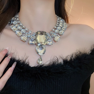 Detailed view of silver statement necklace with heart and drop-shaped crystal pendants