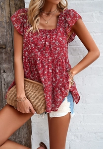 Detail of red floral sleeveless top with square neck and ruffled edges in a summer style