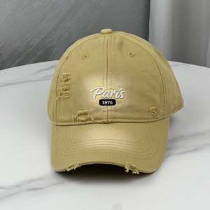 Close-up of khaki distressed baseball cap with Paris embroidery and 1976 patch detail