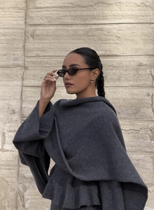 Détail du poncho en tricot gris foncé avec revers large et texture de tissage premium