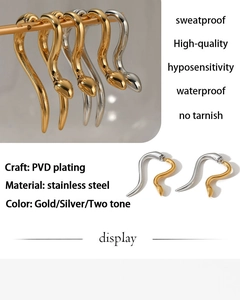 Macro detail of snake-shaped PVD plated stainless steel earrings in gold and silver