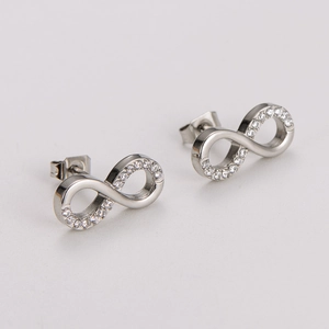 Détail de boucles d'oreilles signe infini avec zircons cubiques sertis sur métal argenté