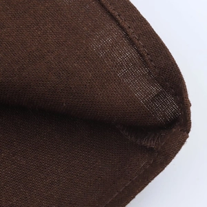 Vue macro de la texture en lin marron foncé et des coutures précises de la robe sans manches