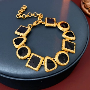 Detailed top view of a vintage geometric gold bracelet with black enamel inlays