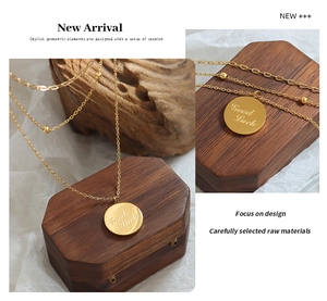 Detail of double-layer 18K gold plated necklace with small beads and Good Luck round pendant