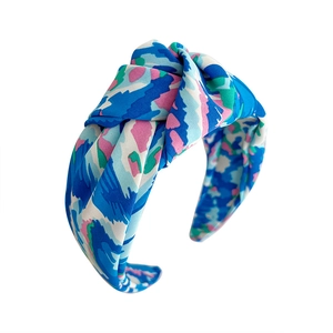 Knotted wide headband with vibrant floral print in royal blue and pink satin fabric
