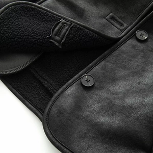 Detail of black faux suede jacket featuring warm fleece lining and round button closure