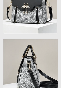 Detail of embroidery contrast handbag with swan metal buckle and pearl pendant detail