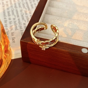 Détail de la bague vintage double couche dorée avec zircons en étoile sur une boîte