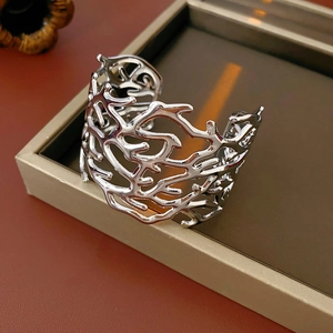 Macro detail of silver hollow coral-shaped open cuff bracelet in a jewelry gift box