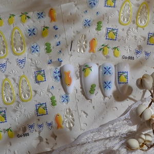Detailed view of lemon and floral nail stickers on pointed artificial nails with lace decor