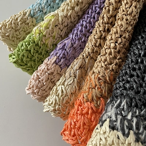 Dettaglio macro della trama in paglia intrecciata in varie sfumature di colori vivaci