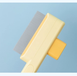 Detail view of dense stainless steel teeth and orange handle on the pet grooming comb