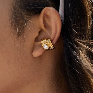 Dettaglio dell'orecchino a clip in acciaio placcato oro 18K con zircone a goccia