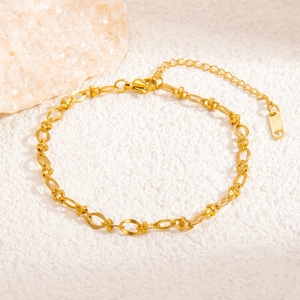 Detail of gold titanium steel woven link bracelet with adjustable chain on mineral stone