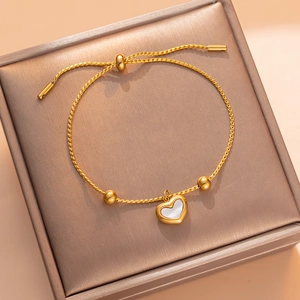 Adjustable gold heart bracelet with white mother of pearl inlay on jewelry box