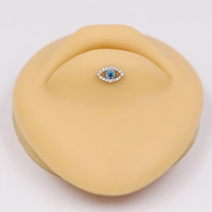 Macro view of evil eye labret stud with blue and white zircons on silicone lip model
