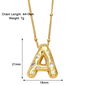 Vue détaillée du pendentif lettre A dorée avec texture lave et pierres zircon