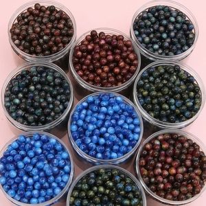 Spherical cat-eye resin beads in circular clear containers for DIY jewelry making